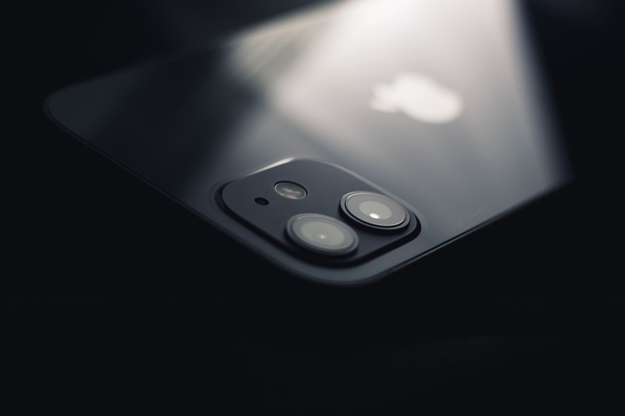 heros-img Close-up shot of a smartphone camera lens reflecting light, highlighting modern technology.